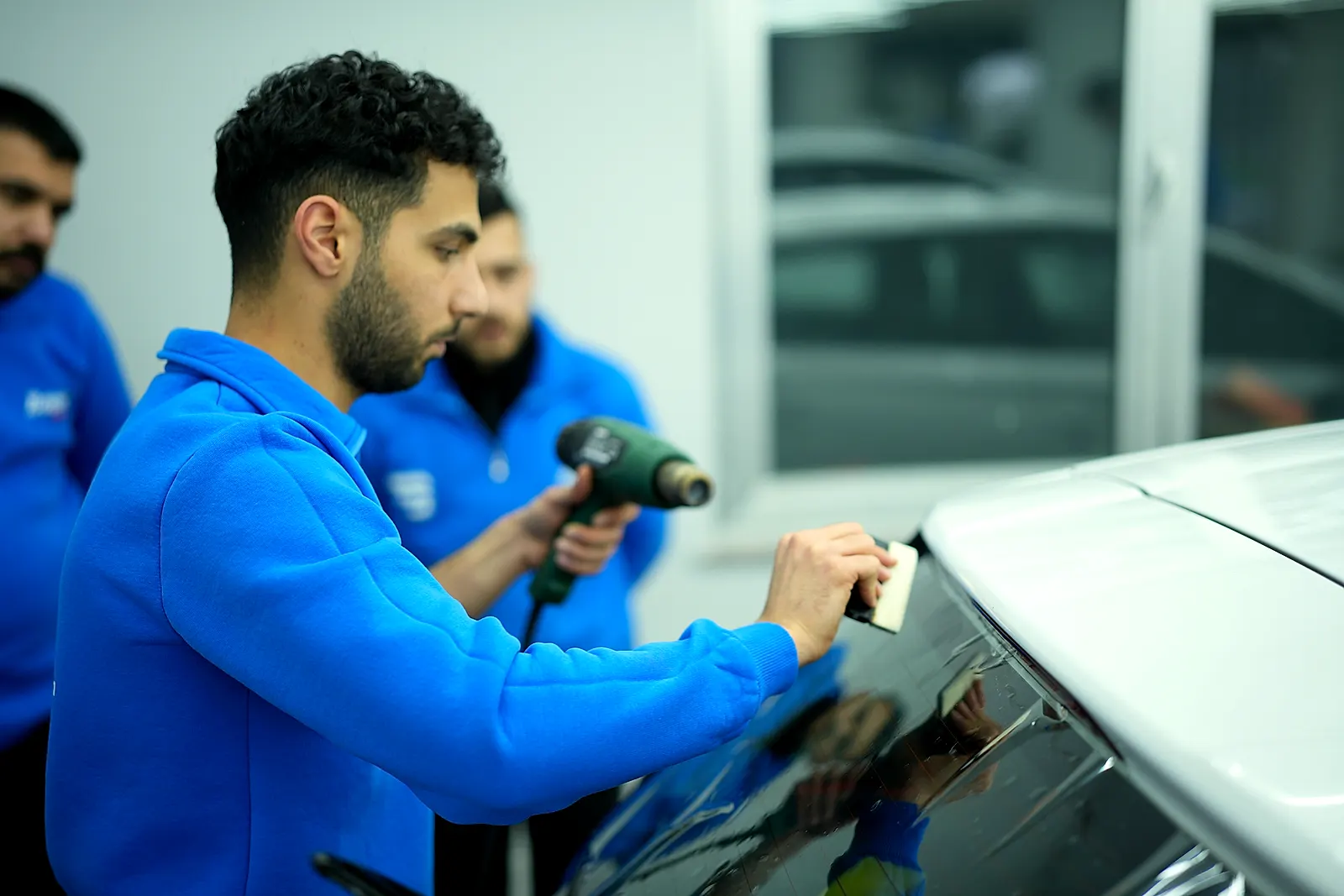 Bowax Academy atölyesinde katılımcı araç camına film uygularken